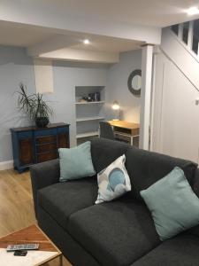 a living room with a gray couch with pillows at 2 Agars Lane Cashel in Cashel