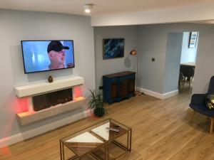 a living room with a fireplace and a flat screen tv at 2 Agars Lane Cashel in Cashel