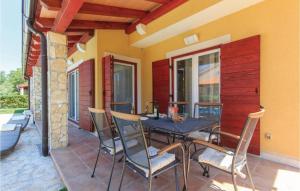 een patio met een tafel en stoelen op een veranda bij I & M Guest House in Banjole