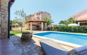 een zwembad met twee stoelen en een huis bij I & M Guest House in Banjole