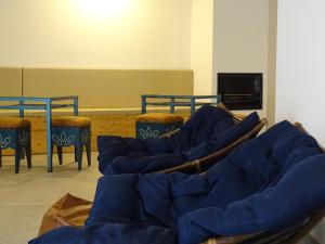 a room with blue chairs and tables and a tv at Casazul M&B in Cercal