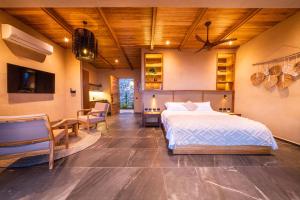 サンタ・テレサにあるLALOON Luxury Suites - Adults Onlyのベッドとテーブルと椅子のある寝室