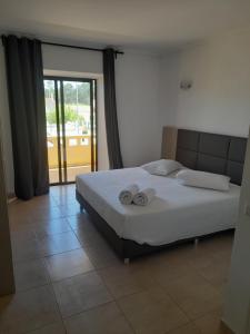 een slaapkamer met een bed met twee handdoeken erop bij Flor de Sal in Vila Real de Santo António
