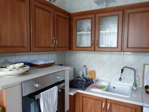 una cocina con armarios de madera y fregadero en Wagner Apartman Tata, en Tata