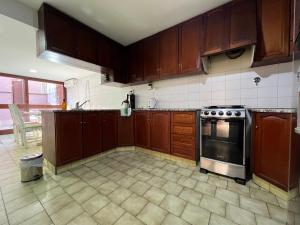 an empty kitchen with wooden cabinets and an oven at Casa Eusebio Blanco con patio parrilla y cochera en el centro de Mendoza in Mendoza