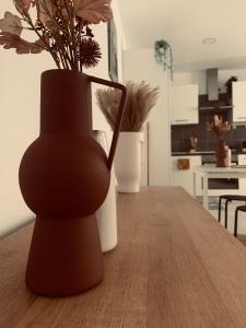 a black vase sitting on a table with flowers at Studio Girafe, style bohème et atypique, Curistes in Luxeuil-les-Bains