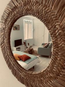 espejo que refleja un dormitorio con cama y sofá en Studio Girafe, style bohème et atypique, Curistes en Luxeuil-les-Bains