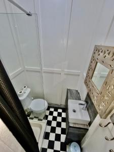 a bathroom with a sink and a toilet and a mirror at Elmora House in Blackpool