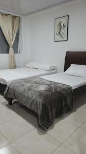 a bedroom with two beds and a blanket on the bed at Edificio Tony - Alojamiento Aparta-Hotel in Barrancabermeja