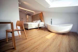 a room with a bath tub and a bedroom at Hotel Boutique Berazadi Berri in Zarautz