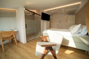 a bedroom with a bed and a table and a chair at Hotel Boutique Berazadi Berri in Zarautz