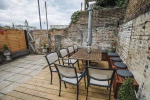 eine Terrasse mit Tisch und Stühlen und einer Backsteinmauer in der Unterkunft Stunning 5 bedroom period property by the sea in Kent