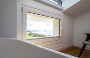 a window in a room with a view of the ocean at Hotel Boutique Berazadi Berri in Zarautz