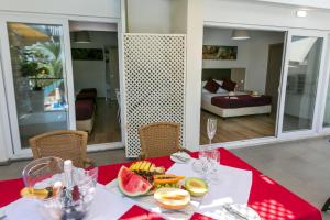 a table with a plate of fruit on a red table cloth at Fitosinn Hotel in Paphos