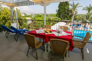 a table on a balcony with a view of a pool at Fitosinn Hotel in Paphos