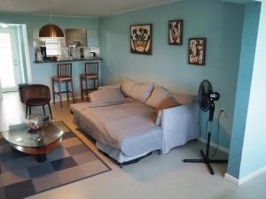een slaapkamer met een bed en een tafel in een kamer bij Kas di BaMi A-186 op Seru Coral Resort - Ruim appartement met groot zwembad en tropische tuin in Willemstad
