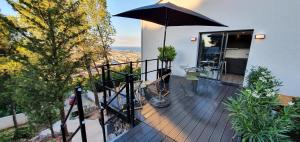 einen Balkon mit einem Regenschirm auf einem Haus in der Unterkunft Studio terrasse Indépendante Vue Exceptionnelle in Sète