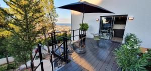 a balcony with an umbrella on top of a house at Studio terrasse Indépendante Vue Exceptionnelle in Sète