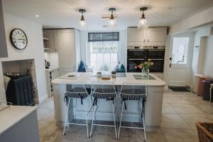 eine Küche mit einer Insel mit Barhockern in der Unterkunft Stunning 5 bedroom period property by the sea in Kent