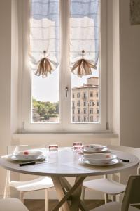 una mesa blanca con 2 sillas y una ventana en InnPisaRentals - La Fortezza Apartment, en Pisa