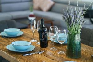 "The 7th Heaven Garden" Villa في فوديس: طاولة مع زجاجة من النبيذ وكؤوس النبيذ