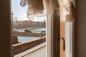 Habitación con ventana y vistas a un puente. en InnPisaRentals - La Fortezza Apartment, en Pisa