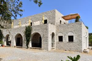 a stone house with a balcony on top of it at Akroyiali Apartments in Gerolimenas