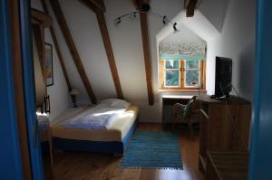 um pequeno quarto com uma cama e uma janela em Hotel Schwarzer Adler em Erlangen