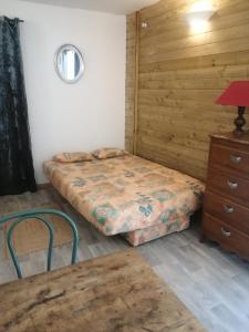 a bedroom with two beds and a dresser and a table at L'Ancienne Ecole in Silhac