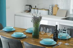 a wooden table with blue plates and wine glasses at "The 7th Heaven Garden" Villa in Vodice