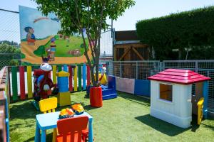 a childrens play area with a playground with chairs and toys at Fitosinn Hotel in Paphos