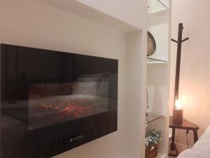 a tv on a wall with a fireplace in a room at Live House Boutique in São Paulo