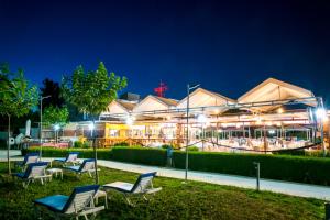 a building with chairs in front of it at night at Fitosinn Hotel in Paphos
