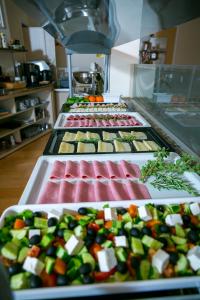 a row of trays filled with different types of food at Fitosinn Hotel in Paphos
