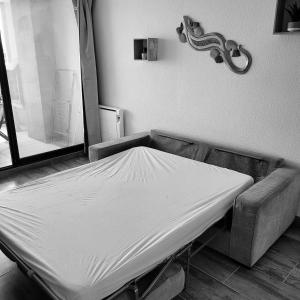 um quarto de hospital com uma cama e um sofá em Superbe appartement avec piscine em Le Barcarès