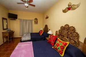 1 dormitorio con 2 camas y ventilador de techo en Posada Maria Luisa, en San Miguel de Allende