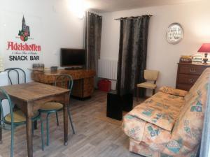 a living room with a table and a bed and a desk at L'Ancienne Ecole in Silhac