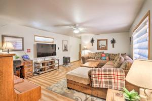 a living room with a couch and a flat screen tv at Hot Tub and Deck Big Bear Gem Near Resorts! in Big Bear Lake