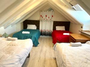 um quarto no sótão com 3 camas e um telhado em Sight Qoricancha em Cusco