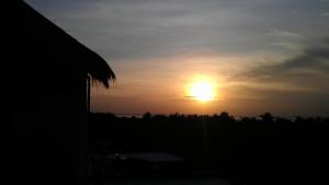 a sunset with the sun in the sky at Mui Ne Hills Budget Hotel in Mui Ne