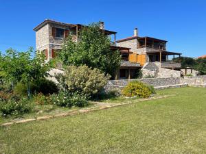 a large stone house with a yard in front of it at Evgatis Beach Luxury Apts in Th&aacute;nos