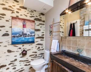a bathroom with a toilet and a lighthouse on the wall at Gite Kerlaguito in Pontchâteau