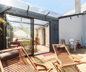 a patio with two chairs and a sliding glass door at Gite Kerlaguito in Pontchâteau