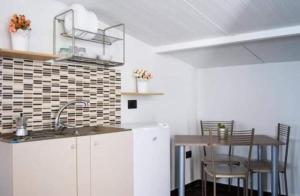 a kitchen with a sink and a table with chairs at CRISVAN HOME in Capo Rizzuto