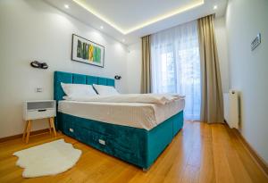 a bedroom with a blue bed and a window at Kedar apartment in Novi Sad