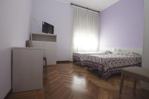 biały pokój z 2 łóżkami i telewizorem w obiekcie Italy Inn w Genui