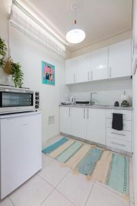 a kitchen with white cabinets and white appliances at Cozy&Quiet Nest in Loutraki