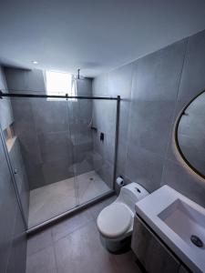 a bathroom with a shower and a toilet and a sink at Eslait Hotel & Apartamentos in Barranquilla