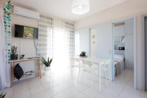 a living room with a white table and a bed at Loutraki Getaway - Cozy and Quiet Nest in Loutraki