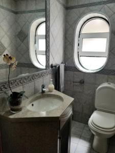 a bathroom with a sink and a toilet and a mirror at Casa Bonequinha in Nazaré +28 photos